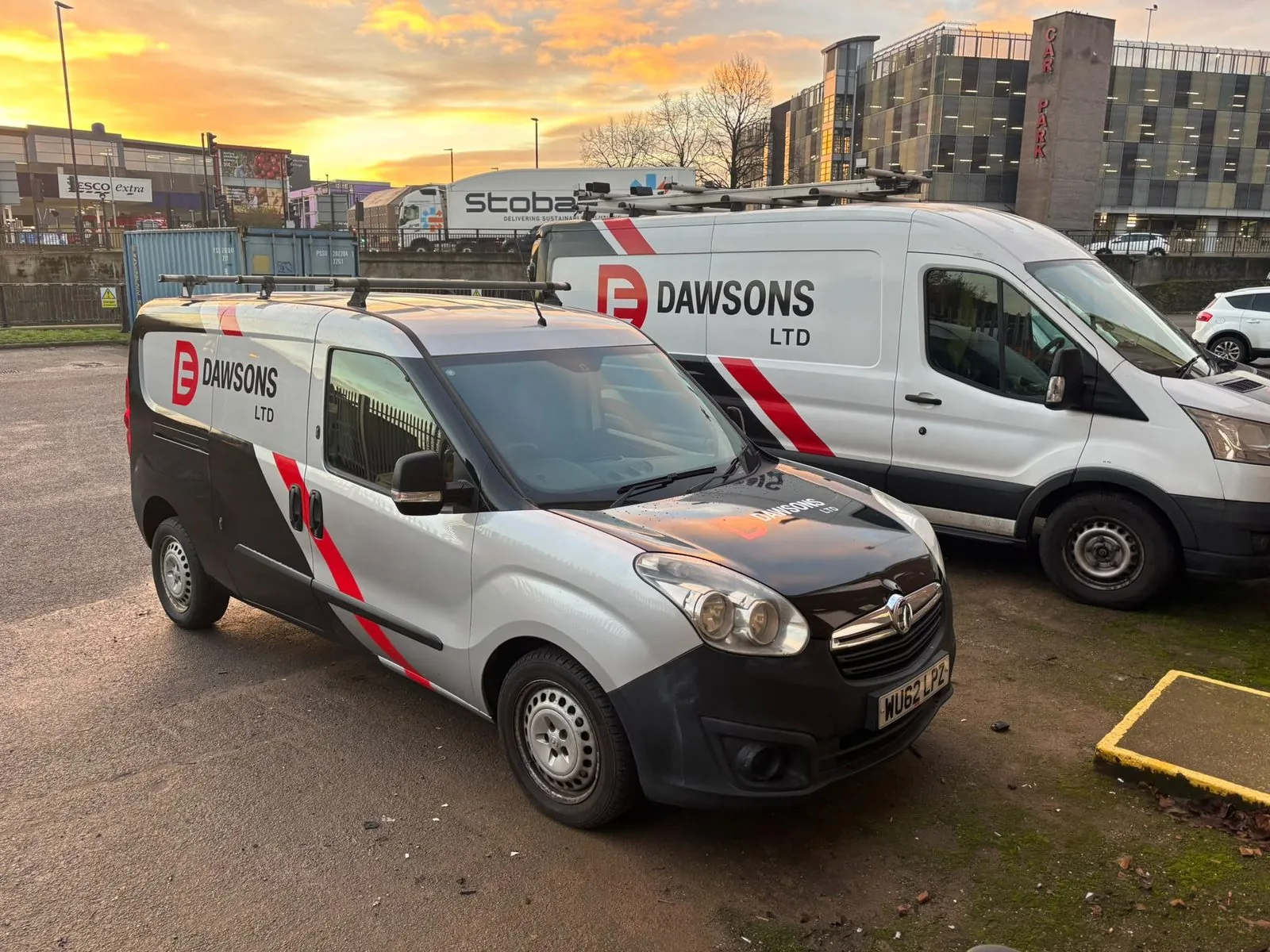 Two liveried Dawsons Ltd vans parked side by side at sunrise